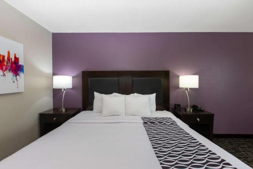 a hotel room with a large bed with two lamps at La Quinta by Wyndham Blue Springs in Blue Springs