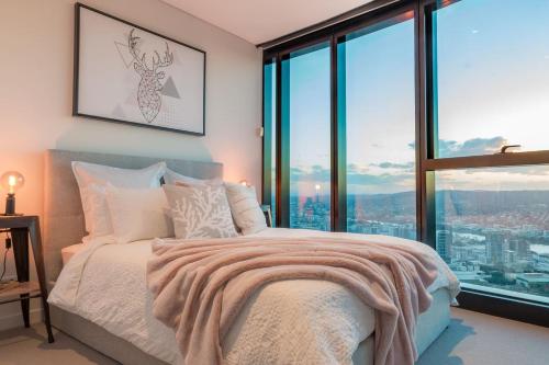 a bedroom with a bed and a large window at Highlife Luxury*Carpark*Wifi*Pool*Gym*Netflix in Brisbane