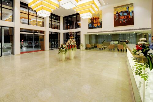 a lobby with tables and chairs in a building at Ramada by Wyndham Bengaluru Yelahanka in Yelahanka