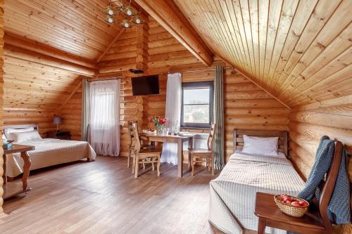 Un dormitorio con 2 camas y una mesa en una habitación en Tourist Complex belaya Reka Dakhovskaya, en Dakhovskaya