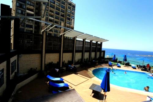 a swimming pool on the side of a building at Private Room In Apartment with Sea & Hilton View in Alexandria