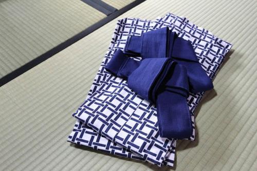 a blue bow sitting on top of a bed at 小さなお宿 乃むら in Kanazawa