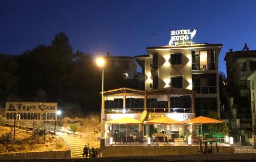 a hotel with a sign on top of it at night at Hotel Hugo in Altınoluk