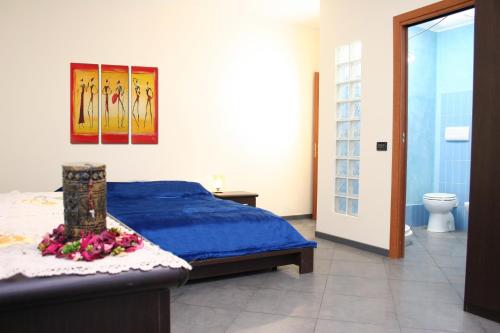 a bedroom with a blue bed and a toilet at Villa Carmela in Sessa Aurunca
