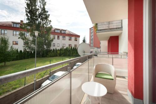 B2B Apartments في جيهلافا: شرفة على طاولة وكراسي في مبنى