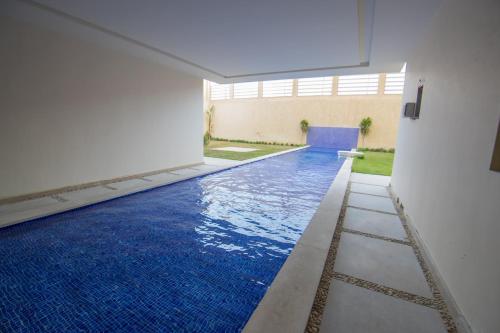 una piscina con suelo de baldosa azul en un edificio en The Home Dreamland, en Seis de Octubre