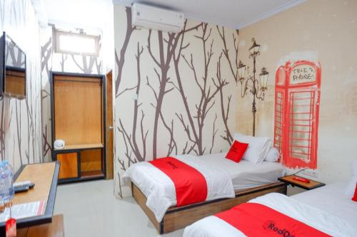 1 dormitorio con cabina de teléfono roja en la pared en RedDoorz Syariah near Universitas Negeri Gorontalo 2 en Gorontalo