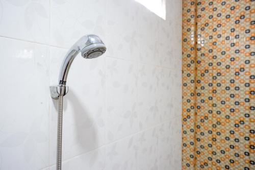 a shower with a shower head in a bathroom at RedDoorz Syariah near Universitas Negeri Gorontalo 2 in Gorontalo