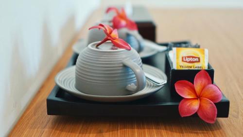 a tray with a cup and plates and a flower at Perissos Echo Beach in Canggu