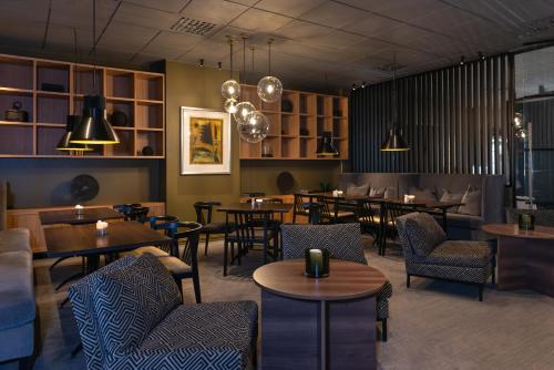a restaurant with many tables and chairs and lights at Quality Hotel Sarpsborg in Sarpsborg