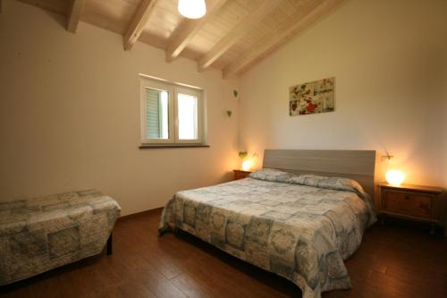 una camera con due letti e una finestra di Due casette con Piscina a Castagneto Carducci