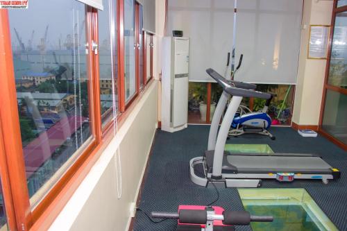 a room with a gym with a treadmill and a window at Lac Long Hotel Hai Phong in Hai Phong