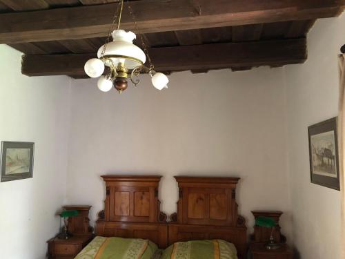 1 dormitorio con cama y lámpara de araña en Alinda apartman, en Magyarszombatfa