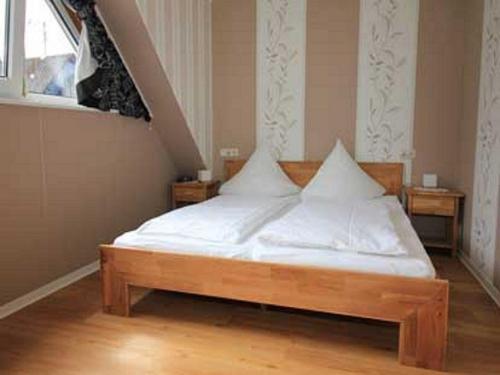 a bed with white sheets and pillows in a room at Ferienwohnungen Georg Andre Söhne in Ernst