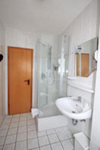 a bathroom with a sink and a shower and a toilet at Ferienwohnungen Georg Andre Söhne in Ernst