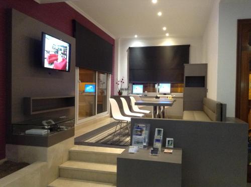 a living room with a table and a television on a wall at Hotel Vila da Guarda in A Guarda