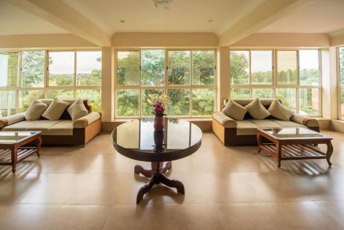 a large living room with couches and a table at Bota Royal in Kushālnagar