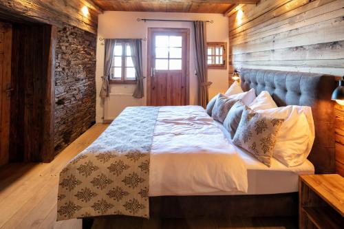 een slaapkamer met een bed en een bakstenen muur bij Das Holzpoidl in Greisdorf