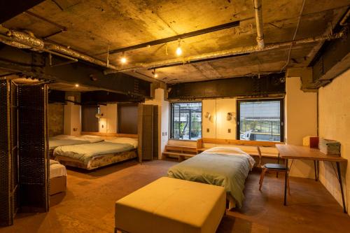 Guest House M104 Kagoshima في كاجوشيما: غرفة بسريرين وطاولة فيها