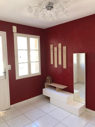 Zimmer mit roten Wänden und einer Bank an der Wand in der Unterkunft Bâtisse du pont Pinard et son granit rose in Semur-en-Auxois