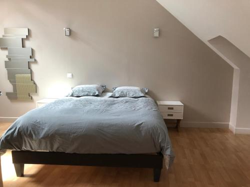 - une chambre blanche avec un lit et un escalier dans l'établissement Bâtisse du pont Pinard et son granit rose, à Semur-en-Auxois