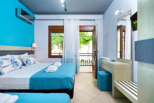 a blue bedroom with a bed and a tub and a sink at Studios Panagiotas House Astris in Astris