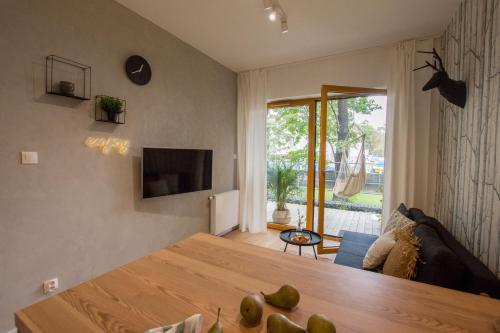 sala de estar con mesa de madera y TV en Rakowicka Apartment, en Cracovia