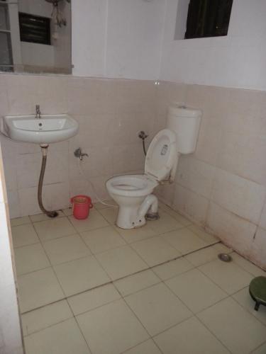a bathroom with a toilet and a sink at Rose Cottage in Mount Ābu