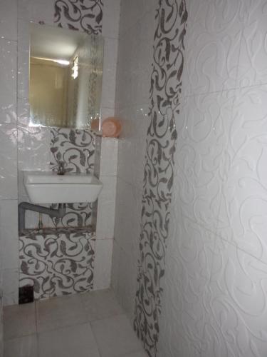 ein Bad mit einem Waschbecken und einem Spiegel in der Unterkunft Hotel Kiran in Mount Ābu