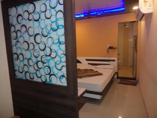 eine Tür zu einem Zimmer mit einem Bett und einem Spiegel in der Unterkunft Exotic Stay Near Shivaji Marg in Mount Ābu