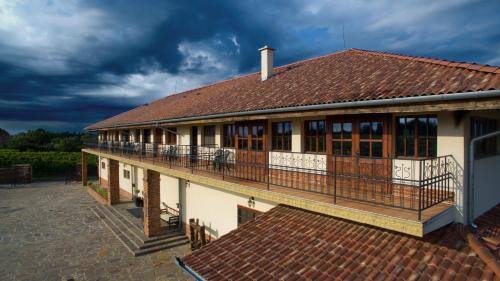 a house with a balcony and a roof at Ebner Pince - Panzió in Turbékpuszta