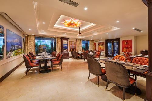 a restaurant with tables and chairs in a room at MAYFAIR Lake Resort in Raipur