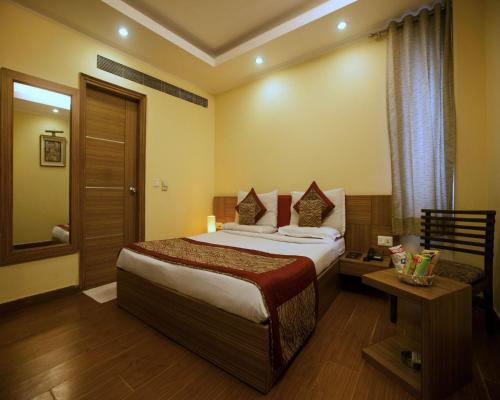 um quarto de hotel com uma cama e uma janela em The Pearl- A Royal Residency em Nova Deli