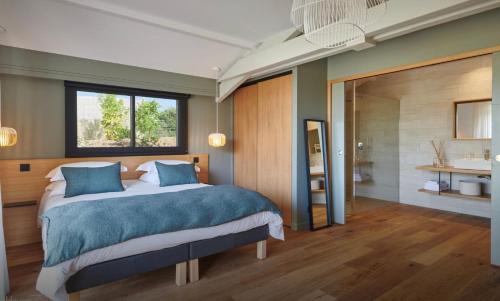 a bedroom with a large bed and a bathroom at Le Cabanon Bidart in Bidart