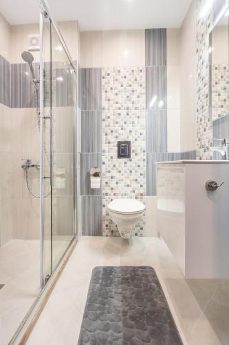 a bathroom with a shower and a toilet and a sink at NC Apartment Ruse in Ruse
