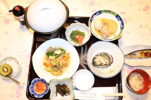 un plateau rempli de plats sur une table dans l'établissement タカマス民宿, à Ōtsuchi