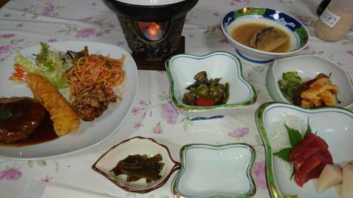 a table topped with plates of food and bowls of food at タカマス民宿 in Ōtsuchi
