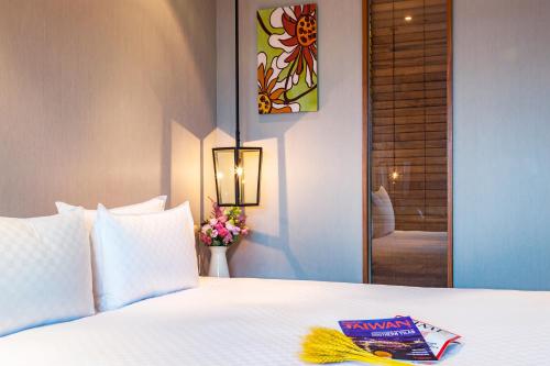 a hotel room with a bed with a book on it at Pacific Business Hotel in Taipei