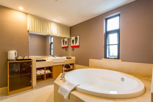 北京市にあるJingli Hongyizhan Hotel Beijing Sanlitunの浴槽と洗面台を備えた広いバスルーム