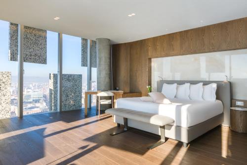 a bedroom with a white bed and a desk and windows at Maritim Hotel Plaza Tirana in Tirana