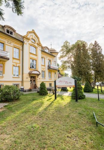 a large yellow building with a sign in front of it at Hotel Bella in Jelenia Góra