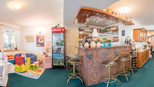 a bar in a store with stools around it at Hotel Bella in Jelenia Góra