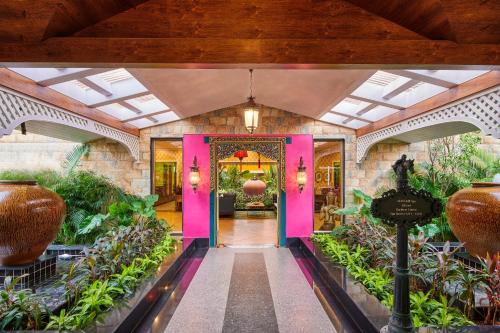 an entrance to a house with pink doors and plants at MAYFAIR Lake Resort in Raipur