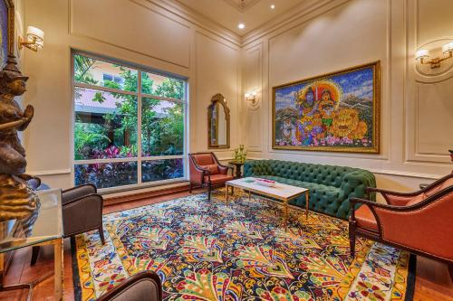a living room with a green couch and a large window at MAYFAIR Lake Resort in Raipur