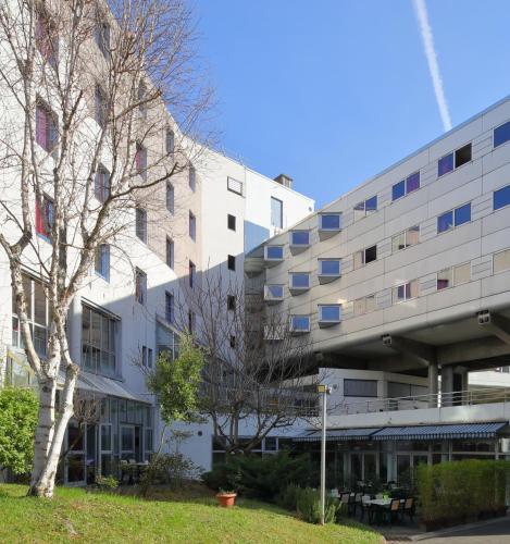 a building with a tree in front of it at Hotel CIS Paris Kellermann in Paris