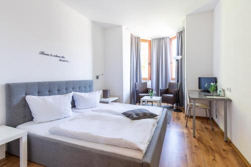 a bedroom with a bed and a desk with a computer at Hotel Garni Zum Dorfbrunnen in Bornheim