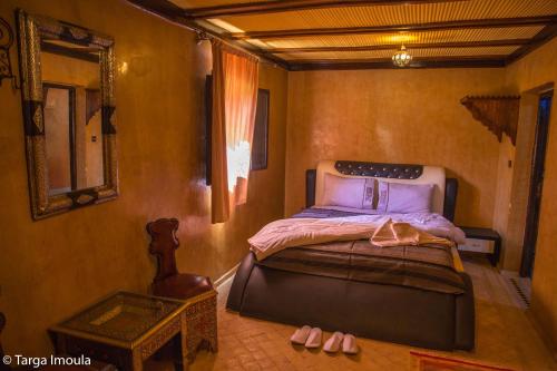 a bedroom with a bed and a table with pink shoes at Targa Imoula in Imlil