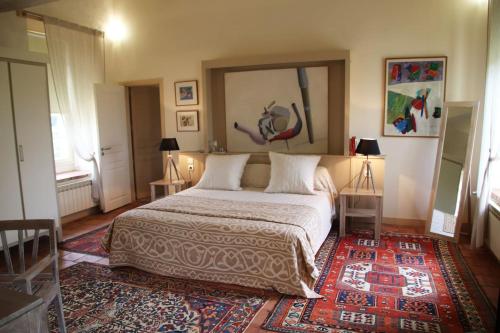 a bedroom with a large bed and a rug at LES ECURIES DU CHATEAU TAUZIET in Montfort-en-Chalosse