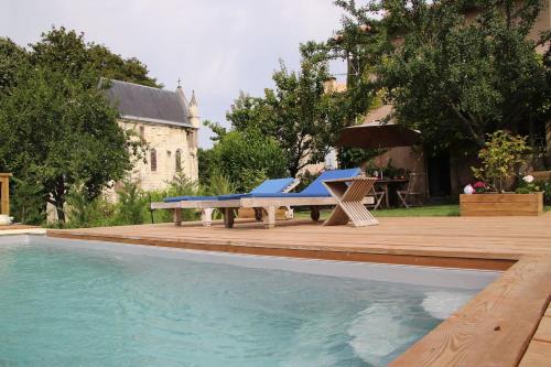 a swimming pool with a wooden deck and a picnic table at LES ECURIES DU CHATEAU TAUZIET in Montfort-en-Chalosse