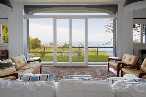 a living room with white furniture and large windows at ATeRIAN LAZKANO ENEA in Getaria